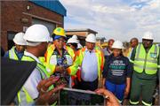 Minister Majodina with the Deputy Minister Mahlobo and Mayor of the City of Tshwane listening to the project manager at Klipdrift Package Plant